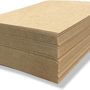 May include: A stack of brown craft paper sheets. The paper is smooth and has a slightly textured surface.