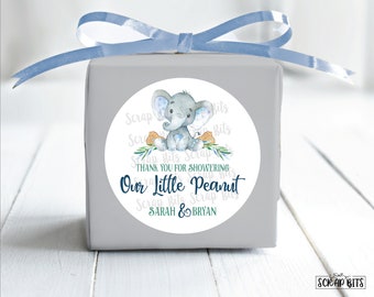 May include: Round favour tag with a watercolour illustration of a blue and grey elephant sitting on a peanut. The tag has green leaves and the text "Thank you for showering our little peanut Sarah & Bryan".