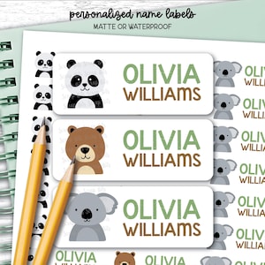 Peut inclure: Une feuille d'étiquettes nominatives rectangulaires personnalisées avec des illustrations de panda, d'ours brun et de koala. Chaque étiquette affiche le nom Olivia Williams en texte vert et marron. La feuille comprend deux crayons jaunes.