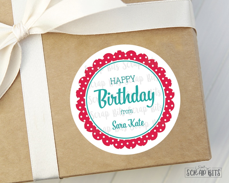 May include: A round, white gift tag with a red and white polka dot border. The tag says "Happy Birthday" in teal script with "from" and "Sara Kate" in teal below.