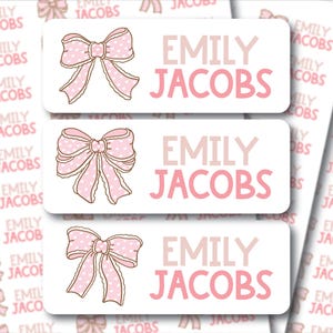 May include: White rectangular stickers with the name "EMILY JACOBS" in pink lettering. Each sticker features a pink bow with white polka dots. The background is filled with similar stickers.