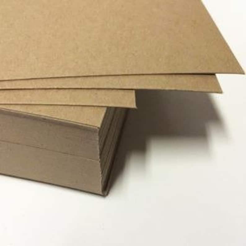 May include: A stack of brown cardboard sheets, showing the texture of the paper.