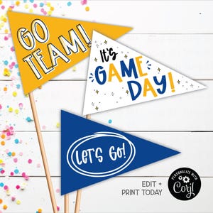 Könnte beinhalten: Drei dreieckige Wimpel auf Holzstäben. Die Wimpel sind gelb, weiß und blau, mit den Aufschriften "GO TEAM!", "It's GAME DAY!" und "Let's GO!" in weißem und blauem Text. Konfetti ist verstreut.