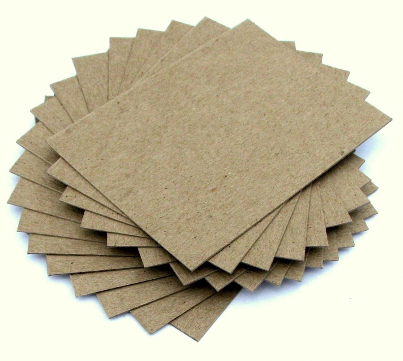 May include: A stack of brown cardboard squares, likely for crafting or scrapbooking.
