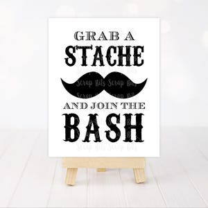 May include: Black and white sign with the text "Grab a Stache and Join the Bash" with a black moustache graphic.