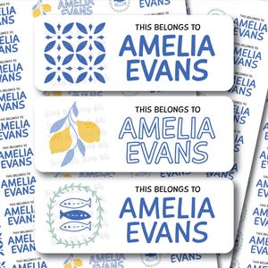 May include: White rectangular labels with blue text that reads "This belongs to Amelia Evans." The labels feature various designs, including a blue and white geometric pattern, lemons, and fish.