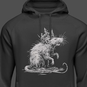May include: Dark gray hoodie featuring a detailed white illustration of a rat wearing a crown. The rat is depicted in a regal pose, with its mouth open and whiskers visible. The hoodie has a drawstring hood.