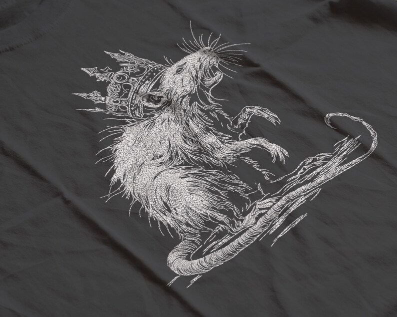 May include: A detailed, embroidered design of a rat wearing a crown, rendered in white thread on a dark gray fabric. The rat is depicted with its mouth open, and its tail curves gracefully. The design has a textured, hand-stitched appearance.