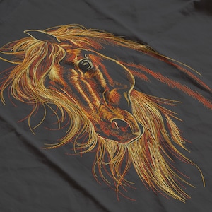 May include: An embroidered horse head design in shades of gold, orange, and brown. The horse's mane and facial features are intricately detailed against a dark gray background. The artwork captures the horse's profile with flowing lines.