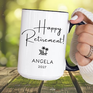 A person is holding a white mug with the text "Happy Retirement!" printed on it.