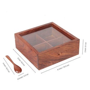 Puede incluir: Una caja de madera con tapa de vidrio y cuatro compartimentos. La caja mide 15,2 cm por 15,2 cm y 5,1 cm de alto. Viene con una peque&ntilde;a cuchara de madera.