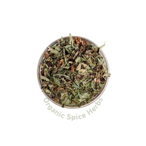 Op de afbeelding: Een glazen kom gevuld met gedroogde groene en bruine kruiden. De kom is gelabeld met "Organic Spice Herbs".