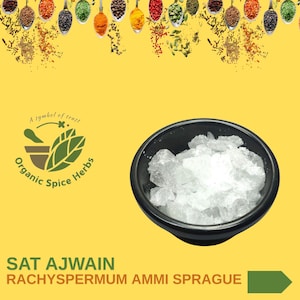 Puede incluir: Un bol negro lleno de semillas de ajwain blancas y cristalinas. El bol está sobre un fondo amarillo con un logotipo verde que dice "Organic Spice Herbs" y el texto "SAT AJWAIN RACHYSPERMUM AMMI SPRAGUE".