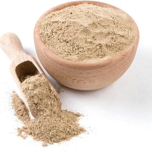 K&ouml;nnte beinhalten: Eine Holzsch&uuml;ssel und ein L&ouml;ffel gef&uuml;llt mit hellbraunem Pulver, wahrscheinlich ein Gew&uuml;rz oder Kraut. Die Sch&uuml;ssel ist rund und der L&ouml;ffel hat einen Griff. Das Pulver versch&uuml;ttet sich auf der wei&szlig;en Oberfl&auml;che und erzeugt eine nat&uuml;rliche und rustikale &Auml;sthetik.