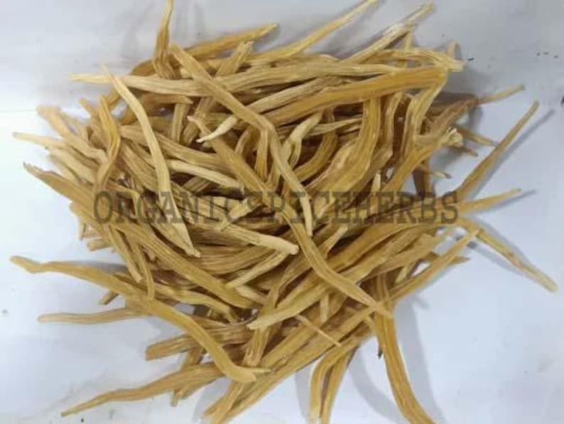 May include: A pile of dried, light brown, slender, and elongated herbs. The herbs are arranged in a dense cluster, with some pieces extending outwards. The text "ORGANIC SPICE HERBS" is visible on the image.