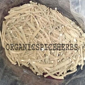 K&ouml;nnte beinhalten: Nahaufnahme eines Beutels gef&uuml;llt mit getrockneten, hellbraunen Wurzeln. Die Wurzeln sind lang und d&uuml;nn und in einem zuf&auml;lligen Muster angeordnet. Der Text "ORGANICSPICEHERBS" ist auf den Wurzeln sichtbar.