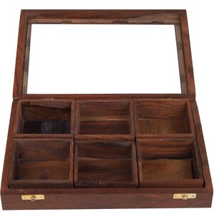 Puede incluir: Una caja de madera con tapa de vidrio y seis compartimentos. La caja es de madera marr&oacute;n oscuro y tiene bisagras de lat&oacute;n.