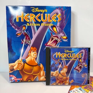 May include: A Disney's Hercules Action Game large box and a matching CD-ROM jewel case for Windows 95. The artwork features Hercules holding a sword, facing two purple multi-headed hydra creatures against a blue background with yellow text.