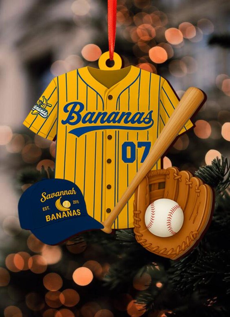 Pode incluir: Enfeite de Natal com tema de beisebol com camisa amarela e azul com "Bananas" e o n&uacute;mero "07", taco de beisebol, luva, bola e bon&eacute; azul com texto "Savannah Bananas". Para a &aacute;rvore de Natal.