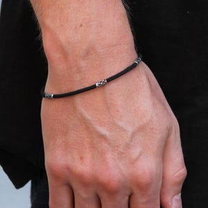 Pulsera sencilla de algodón para hombre, cordón negro con dije plateado, resistente al agua, estilo surfero, pulsera de hilo, ideal para festivales.