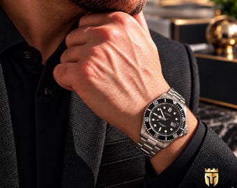 Può includere: Un orologio da polso analogico color argento con quadrante circolare nero, indici luminosi e una ghiera girevole con numeri bianchi. L'orologio presenta un cinturino a maglie in acciaio inossidabile e riporta il marchio DIVODI sul quadrante.