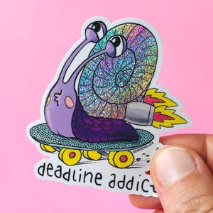 Könnte beinhalten: Ein gestanzter Aufkleber mit einer lila Schnecke mit holografischem Gehäuse auf einem türkisfarbenen Skateboard mit gelben Rollen. Die Schnecke hat ein Triebwerk am Gehäuse, das gelbe und rosa Flammen ausstößt. Der Text lautet deadline addict.