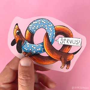 Könnte beinhalten: Ein verspielter Aufkleber mit einem Dackel, der sich in einer Brezelform windet und einen blauen Pullover mit Knochenmuster trägt. Eine Sprechblase zeigt das Wort "SERVUS!". Der Hintergrund ist rosa, die Farben sind lebendig.