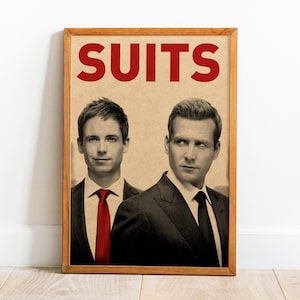 May include: A framed poster featuring two men in suits. The word "SUITS" is printed in large red letters at the top. The men are in black suits, one with a red tie and the other with a black tie. The background is a tan color.