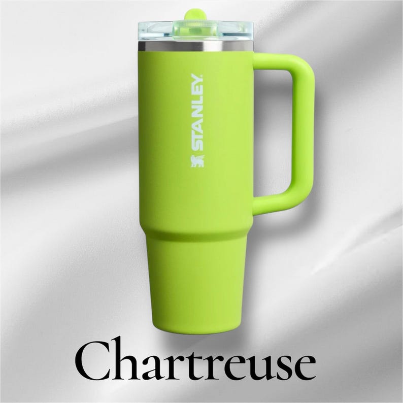 K&ouml;nnte beinhalten: Ein chartreusefarbener Stanley-Becher mit passendem Seitengriff und transparentem Deckel. Der Markenname Stanley ist vertikal in Wei&szlig; auf dem oberen Teil aufgedruckt. Das Wort Chartreuse steht in einer gro&szlig;en, schwarzen Serifenschrift darunter.