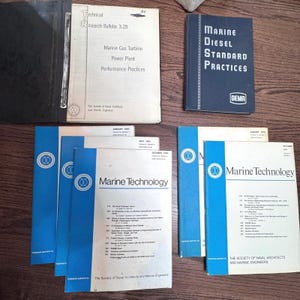 Può includere: Una collezione di pubblicazioni e manuali tecnici vintage, tra cui "Marine Diesel Standard Practices" e diversi numeri di "Marine Technology". I libri presentano copertine blu e bianche, con testo e loghi.