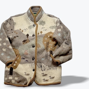 May include: A beige and brown button-up jacket featuring a landscape scene with a house, a cat, a ladder against a tree, and ducks swimming in a pond. The jacket has a high collar, long sleeves, and dark brown trim along the edges and buttons.