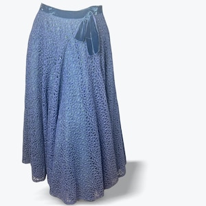 May include: A periwinkle blue skirt with a delicate, openwork lace pattern. The skirt has a high waist and a flowing, full length silhouette. A dark blue velvet bow accents the waistline, adding a touch of elegance to this vintage garment.