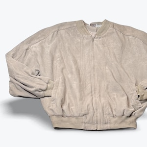 May include: A beige bomber jacket with a full-length zipper, ribbed cuffs, and a ribbed hem. The jacket has two front pockets and a soft, textured appearance. The collar is a lighter shade of beige.