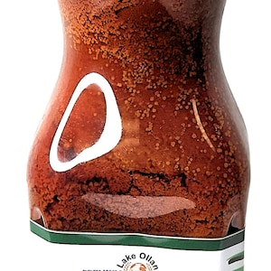 May include: A 1-liter bottle of red palm oil labeled "Torborgee Oil" from Legacy Foods. The bottle has a red cap and a green label with the company logo and the words "Premium Quality".