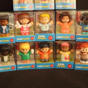 May include: A collection of Fisher-Price Little People figures in their original packaging. Each figure is a different character, with various skin tones, hair colors, and outfits. The packaging includes the text "Little People 1-5".