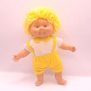 Cabbage patch pop vintage jaren 80. gele haren jongetje van ongeveer 12cm groot met gele tuinbroek