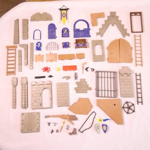 May include: A collection of toy castle components, including walls, doors, windows, a drawbridge, and a banner. The pieces are in various colors, including tan, gray, blue, and brown. There are also ladders, a crossbow, and decorative shields.