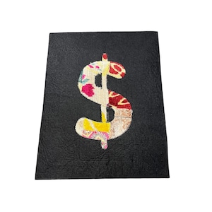 May include: A black felt notebook with a large, colorful dollar sign embroidered on the front.