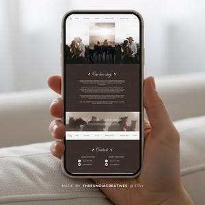 May include: A smartphone displaying a website with a brown and white color scheme. The website features images of couples and horses, with the text "Our love story" and contact information. The phone is held by a person.