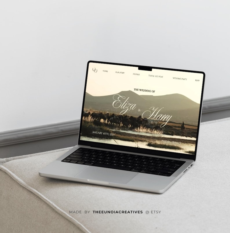 May include: A silver laptop displaying a wedding website design. The screen shows the words "The Wedding of Eliza & Harry" over a landscape image. The laptop is on a light-colored surface, with the text "MADE BY THEEUNOIACREATIVES @ ETSY" at the bottom.