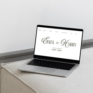 Puede incluir: Un port&aacute;til plateado que muestra un sitio web con el texto "Eliza & Harry" en una elegante escritura. El port&aacute;til est&aacute; abierto y colocado sobre una superficie tapizada de color claro, con una pared blanca de fondo. El sitio web tambi&eacute;n incluye el texto "are getting married".