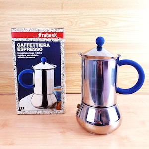 May include: A stainless steel espresso maker with a blue handle and knob, next to its box. The box features the text "CAFFETTIERA ESPRESSO" and an illustration of the espresso maker. The espresso maker is approximately 18 cm tall.