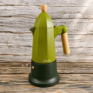 May include: An olive green moka pot coffee maker with a dark green base and a light wood handle and lid knob. The upper body features a small white logo with the text benetton. The design includes a faceted top section and a smooth cylindrical base.
