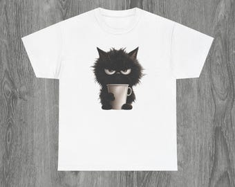 May include: White t-shirt with a cartoon image of a grumpy black cat clutching a coffee mug. The cat has an angry expression. The shirt has a crew neck and short sleeves. The text "SweetandSourPrintz" is at the bottom.