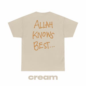 Może przedstawiać: Kremowa koszulka z nadrukiem "ALLAH KNOWS BEST..." w kolorze pomarańczowym na plecach.