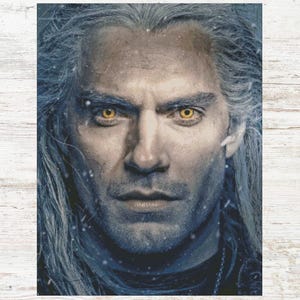 May include: A portrait of a man with long, silver hair and intense yellow eyes. The image has a cool color palette with a focus on the man's face, showcasing detailed features and a serious expression. The background is a blend of blues and grays.