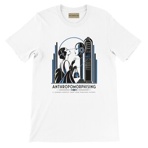 May include: A white short-sleeve t-shirt featuring a black and blue graphic of a person interacting with a robotic server tower. The text reads ANTHROPOMORPHISING and IT LEARNED EMPATHY FROM YOUR PURCHASE HISTORY. The design uses clean lines and geometric shapes.