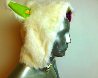 May include: A furry white hat with bright green ears and a yellow accent. The hat is made of soft, fluffy material and is designed to resemble a creature. The hat is displayed on a mannequin.