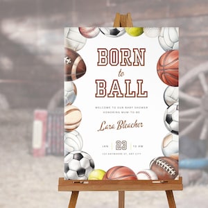 May include: A white sign with a brown border and the text "Born to Ball" in brown letters. The sign is decorated with a border of various sports balls, including basketballs, baseballs, footballs, soccer balls, and volleyballs. The sign also includes the text "Welcome to our baby shower honoring mum-to-be Lara Bleacher" and the date and time of the event.