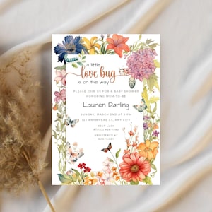 Könnte beinhalten: Eine Babyparty-Einladung mit einem floralen Rand und dem Text "a little love bug is on the way". Die Einladung ist für Lauren Darling und enthält Datum, Uhrzeit und Ort der Party. Außerdem enthält sie die RSVP-Informationen und wo die werdende Mutter registriert ist.